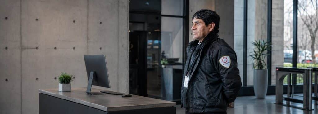 Contratar una empresa de seguridad: vigilador uniformado de STARSEG en la recepción de un edificio corporativo