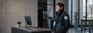 Contratar una empresa de seguridad: vigilador uniformado de STARSEG en la recepción de un edificio corporativo