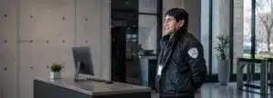 Contratar una empresa de seguridad: vigilador uniformado de STARSEG en la recepción de un edificio corporativo